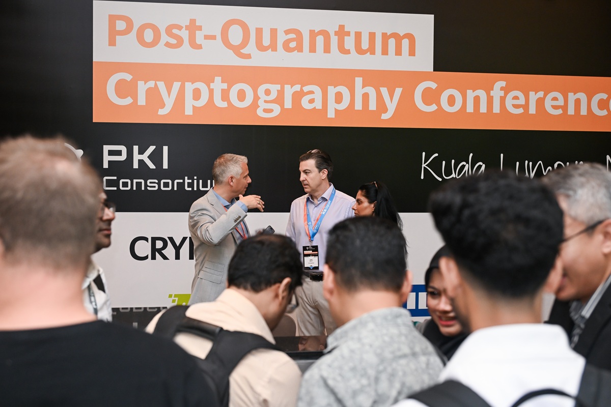 Podium met mensen erop en ervoor op de Post-Quantum Cryptography Conference in Kuala Lumpur in oktober 2025